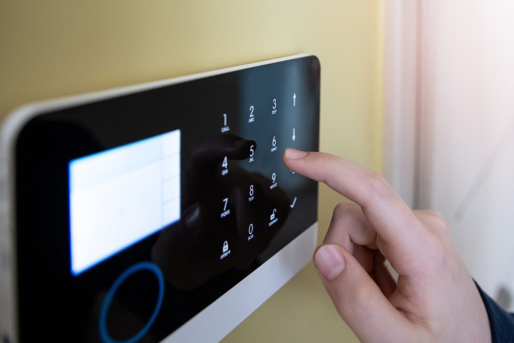 Man’s hand pressing the alarm system button.