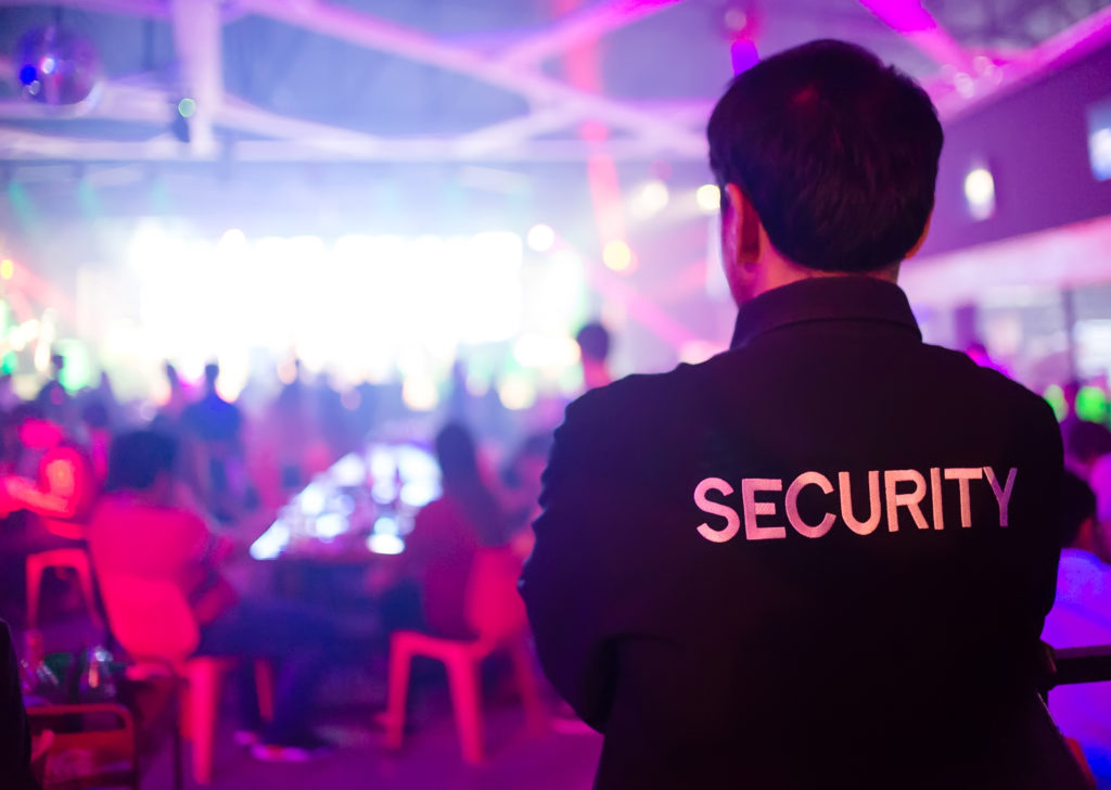 A security guard monitoring a lively event, showcasing the critical role of situational awareness in crowd control.