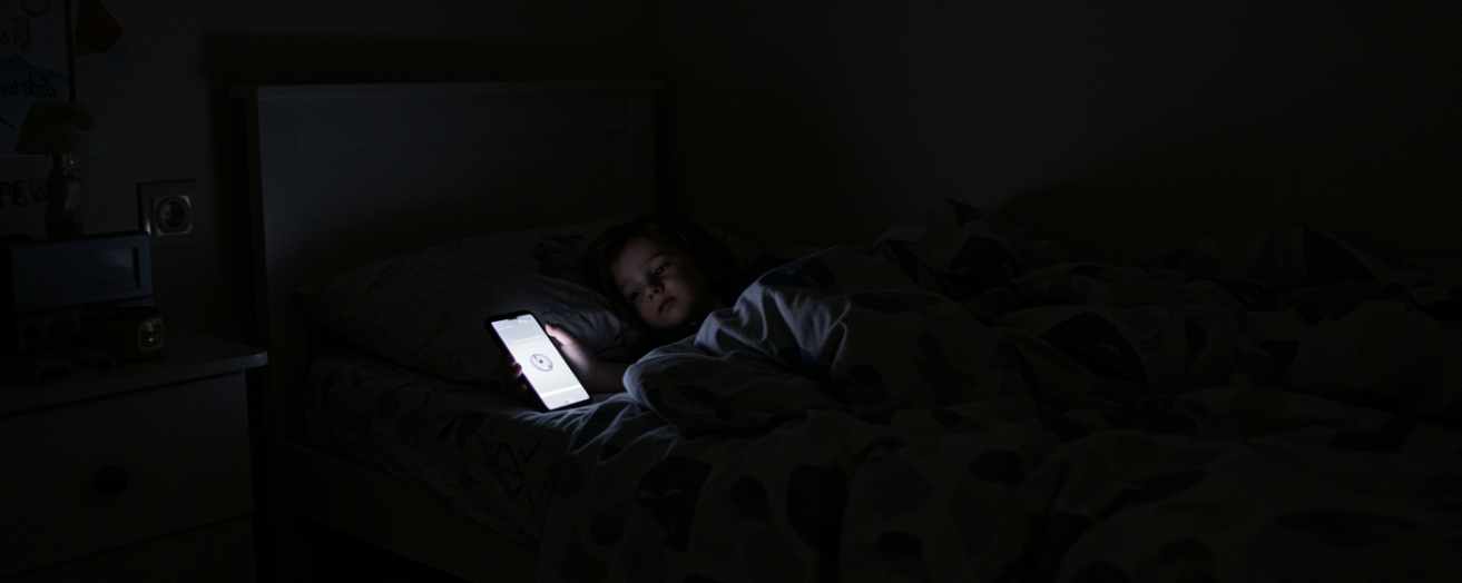 a child using a device at night